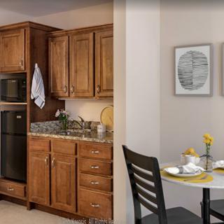 A modern kitchen with wooden cabinets and a cozy dining area.