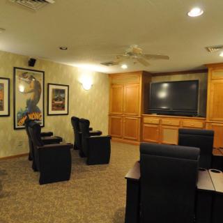 A cozy home theater setup with comfortable seating and a large screen TV.