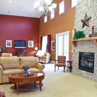 A cozy living room with a stone fireplace, comfortable seating, and elegant decor.