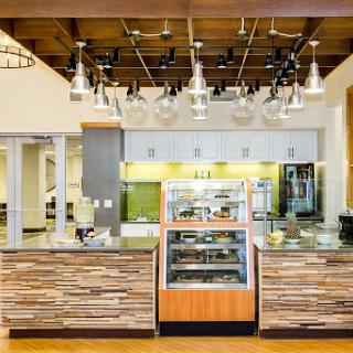 A stylish and modern cafe interior featuring a wooden counter and a bakery display.