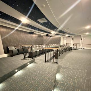 A modern theater interior with tiered seating and a sleek design.