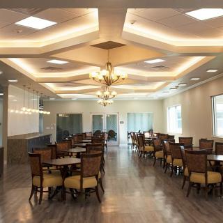 A spacious and well-lit dining area with neatly arranged tables and chairs.