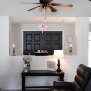 A cozy living room interior with a ceiling fan and stylish decor.
