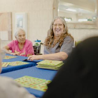 Elderly residents enjoying a game of bingo together, sharing smiles and camaraderie.