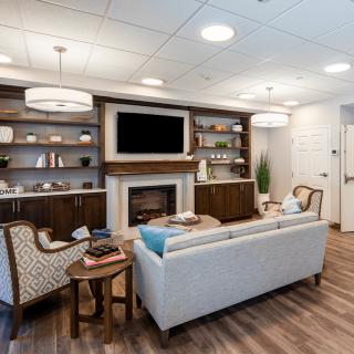 A modern living room with a cozy fireplace, stylish furniture, and elegant decor.