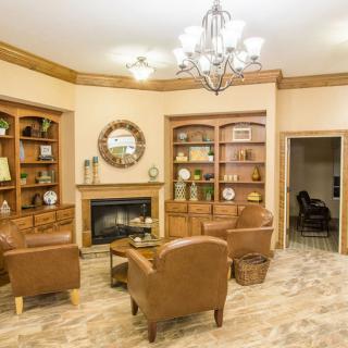 A cozy living room with leather armchairs, a fireplace, and built-in bookshelves.