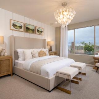 A beautifully designed modern bedroom featuring a cozy bed, stylish furniture, and a stunning chandelier.
