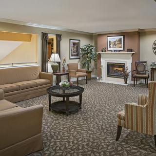 A cozy living room with sofas, armchairs, a coffee table, and a fireplace.