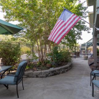 A cozy outdoor patio area with seating and an American flag displayed.
