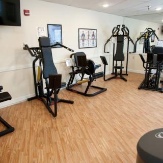 A compact gym with various exercise machines for fitness enthusiasts.