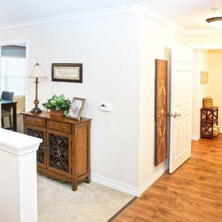 A cozy home hallway featuring a wooden sideboard adorned with decor items and artwork on the walls.