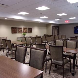 An empty conference room with neatly arranged tables and chairs.
