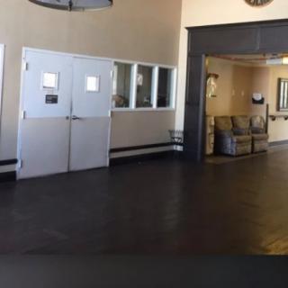 An empty lobby area with white doors and a small waiting area.