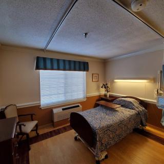 A cozy hospital room with a single bed and window.