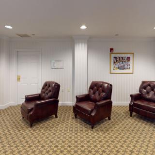 A cozy waiting room with leather chairs and a patterned carpet.