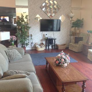 A cozy living room with a comfortable sofa, a wooden coffee table, and a wall-mounted television.