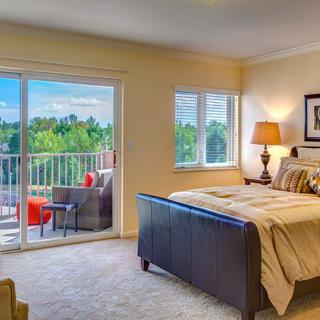 A cozy bedroom with a balcony offering a scenic view.