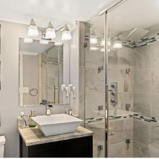 A modern bathroom with a glass-enclosed shower and stylish fixtures.