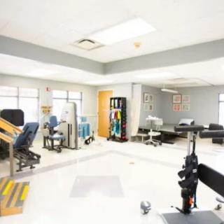 A spacious physical therapy room with various exercise equipment for rehabilitation.
