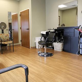 An empty hair salon with chairs, mirrors, and styling equipment.