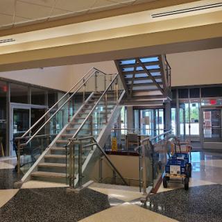 A modern lobby featuring a glass staircase and open design elements.