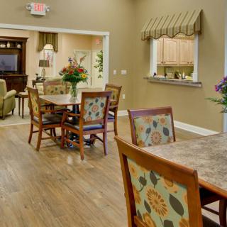 A cozy dining area with floral patterned chairs and wooden floors.
