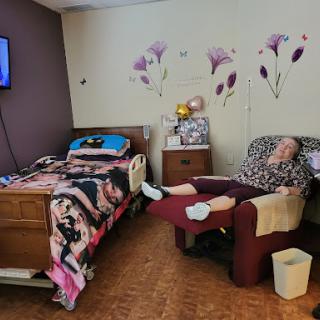 A patient resting in a hospital room, complete with a bed and comfortable chair.