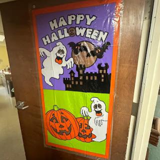 A colorful Halloween decoration featuring ghosts, pumpkins, and a spooky castle.