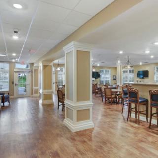 A modern dining area with bar seating and wooden flooring.