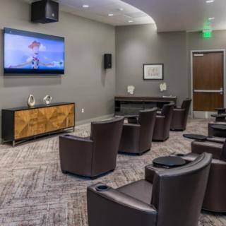 A modern home theater room with comfortable seating and a large TV screen.