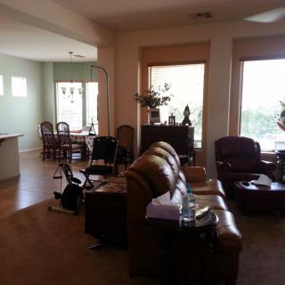 A cozy living room with adjoining dining area, featuring comfortable seating and large windows.