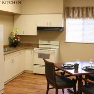 A cozy kitchen with a dining table set and modern appliances.