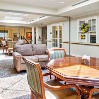 A well-lit living room with comfortable seating and a wooden table.