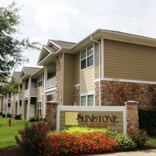 Exterior view of a residential apartment complex with landscaped surroundings.