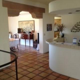 A cozy interior with a tiled floor, featuring a dining area through an archway and stylish decor.