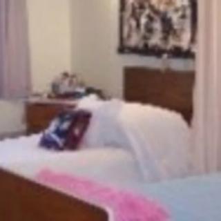 A cozy bedroom with a neatly made bed and colorful decor.