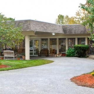 A building with a sheltered entrance and landscaped driveway.