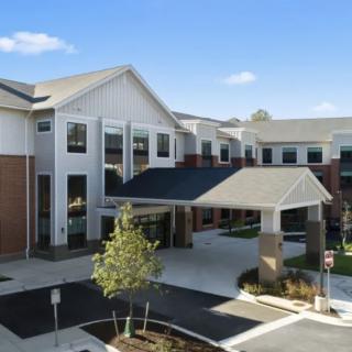 A modern building with a prominent entrance and well-maintained landscaping.