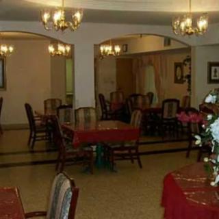 An empty dining area with chandeliers and elegantly arranged tables and chairs.