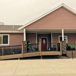 A house with a ramp leading to the front porch, featuring accessible design elements.