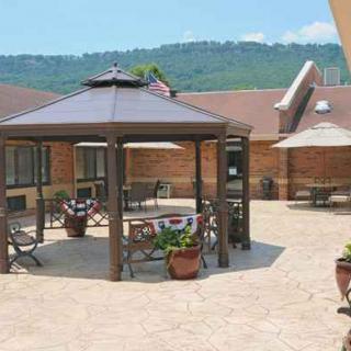 A sunny patio featuring a gazebo with outdoor seating and a scenic mountain view.