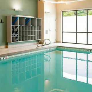 An indoor swimming pool area with natural lighting and a storage area for towels.