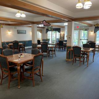 A spacious dining room with wooden furniture and carpeted flooring.