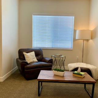 A cozy corner in a modern living space featuring a comfortable armchair, stylish coffee table, and soft lighting.