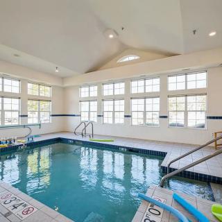 An indoor swimming pool with ample natural light from large windows.