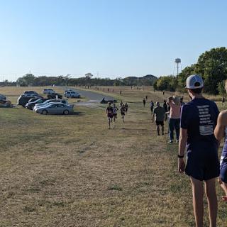Participants walk along a path during an outdoor running event.