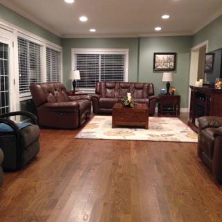 A cozy living room with leather sofas, a wooden coffee table, and ambient lighting.