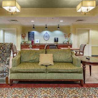 A cozy lobby area with a green sofa and a reception desk in the background.