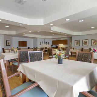 A spacious and well-lit dining area with neatly arranged tables and chairs.