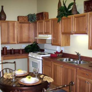 A cozy kitchen with wooden cabinets, a set dining table, and modern appliances.